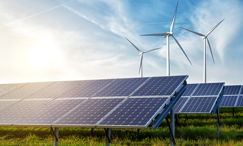 mga solar panel at wind generator sa ilalim ng asul na kalangitan sa paglubog ng araw