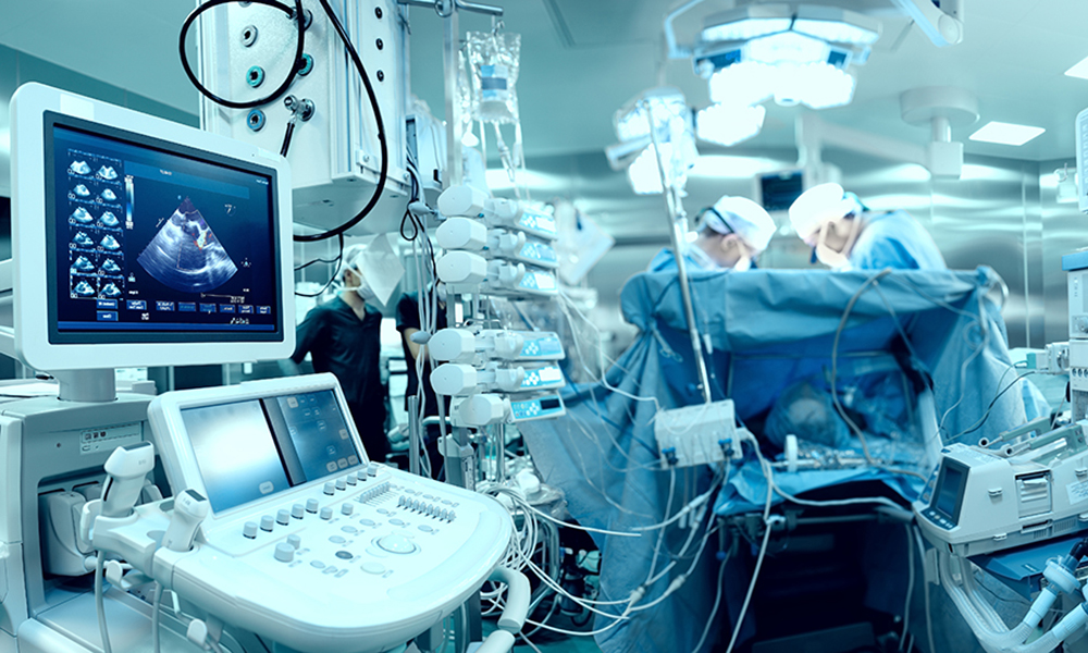 In advanced operating room with lots of equipment, patient and working surgical specialists